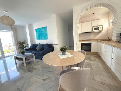 a kitchen and living room with a table and a couch at Villla Clementina in Nerja