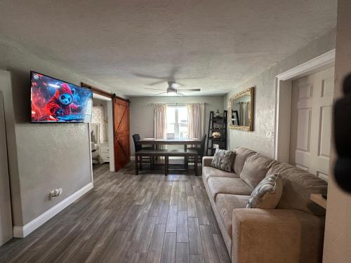 a living room with a couch and a flat screen tv at Deland Serenity Place #1 in DeLand