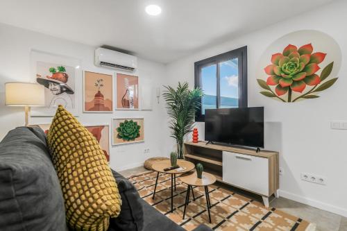 a living room with a couch and a flat screen tv at Living Central Stay Bejeque in Vecindario