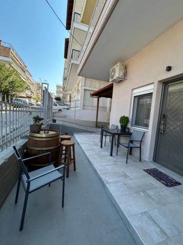 a patio with chairs and tables on a building at Sea&Salt Luxury Rooms in Nea Kalikratia