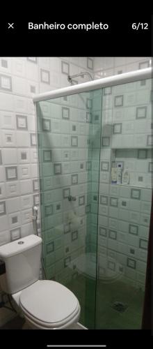 a bathroom with a toilet and a glass shower at Quarto Pedreira Mauriti in Belém