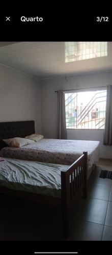 a bedroom with a large bed with a window at Quarto Pedreira Mauriti in Belém