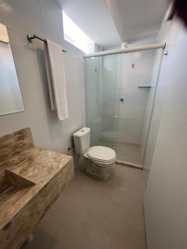 a bathroom with a toilet and a glass shower at Bella Natal praia hotel in Natal