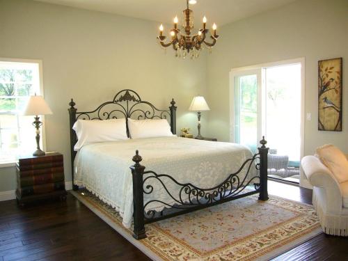 Un dormitorio con una cama y una lámpara de araña. en Villa Napa Wine Country Scenic Pool and Vineyard Views, en Pope Valley