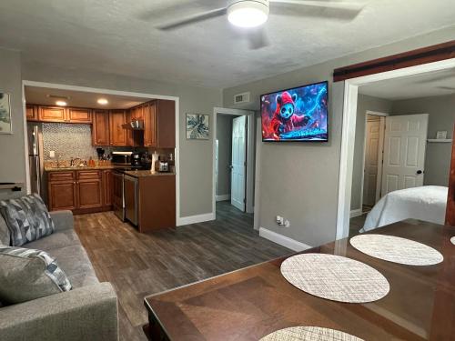 a living room with a couch and a tv on a wall at Deland Serenity Place #1 in DeLand