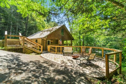 a cabin in the woods with a deck and chairs at On The Rocks in Sevierville