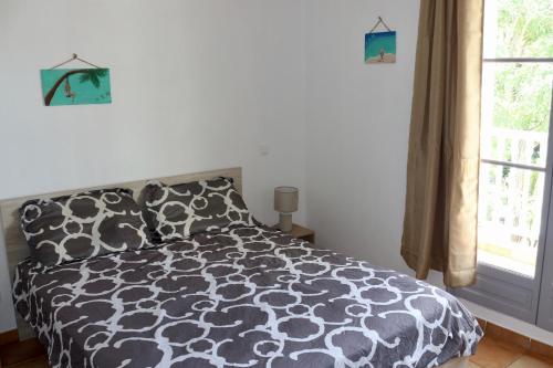 a bedroom with a black and white bed and a window at Villa Redfish in Orient Bay