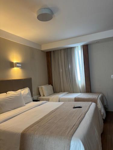 a hotel room with two beds and a window at Linhares Design Hotel 526 in Linhares