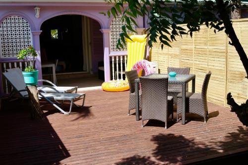 a patio with a table and chairs on a deck at Villa Redfish in Orient Bay
