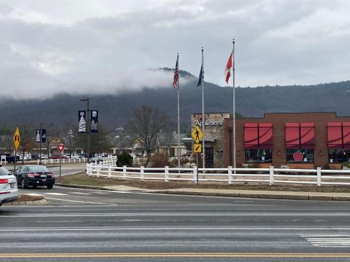 a street with two flags on the side of a road at Modern North Conway Getaway in Conway