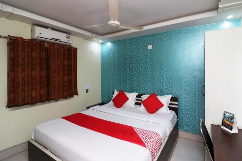 a bedroom with a large bed with red pillows at Hotel O Taj Palace in Tarapith