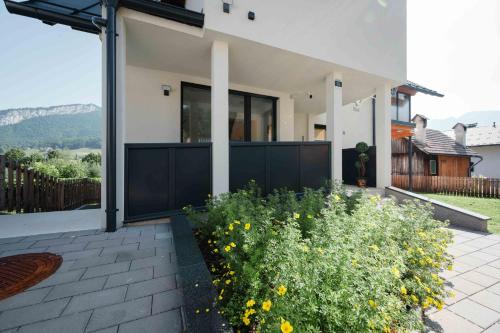 a house with a black fence and yellow flowers at Sepperls Stubn Apartment - PETS no extra cost - Bad Goisern - 24-hours Self check-in in Bad Goisern