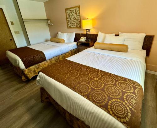 a hotel room with two beds and a lamp at Swiss Village Inn in Golden
