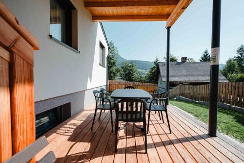 a wooden deck with a table and chairs on it at Sepperls Stubn Apartment - PETS no extra cost - Bad Goisern - 24-hours Self check-in in Bad Goisern