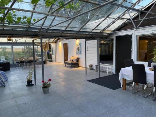 a glass roofed patio with a table and chairs at Köpingebro in Köpingebro