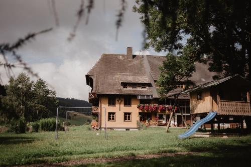 a house with a playground in front of a house at Luxuriöse Schwarzwald Loft Heustock mit Sauna und Whirlpool am Griesbachhof in Titisee-Neustadt