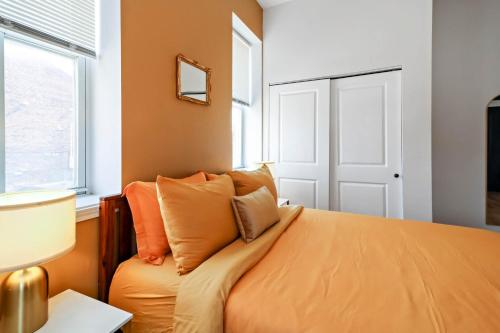 a bedroom with an orange bed and a window at Soulard 4 Bedroom Retreat Near Downtown with Patio and Parking in Soulard