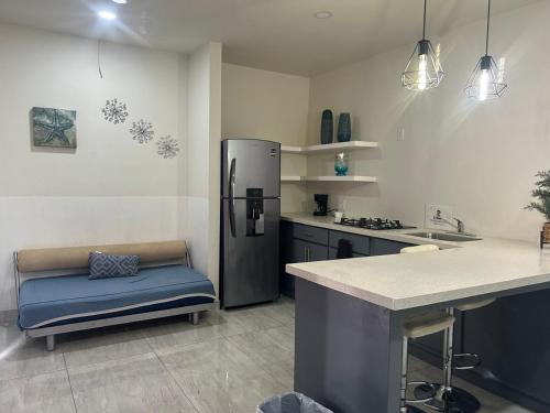 una cucina con un frigorifero e una panca blu di Suite Marvento, Departamento 4 a Ensenada