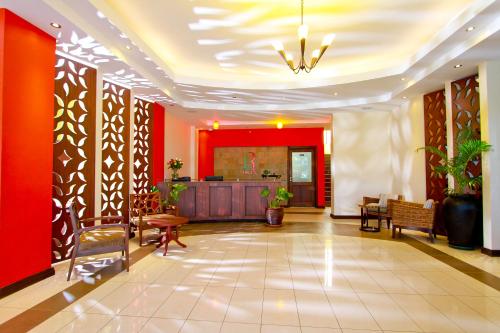 un vestíbulo con paredes rojas, mesas y sillas en Hotel Rio en Nairobi