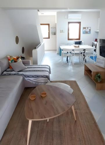 a living room with a couch and a table at Siviri Serenity, 3 minutes walk from the Beach in Siviri