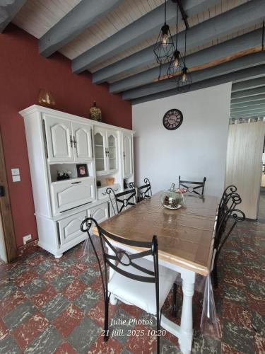 a dining room with a table and a white cabinet at Maison spacieuse 8 couchages proche cascade lac et base de loisirs et de bien être in Lacaze