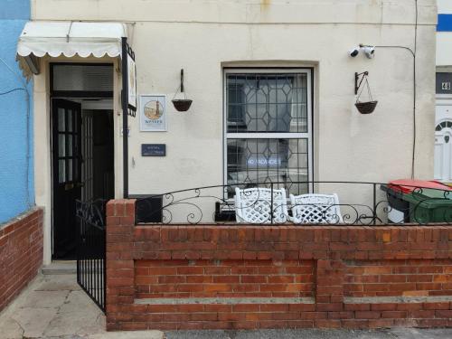 a building with a balcony with chairs and a door at Wessex Guest House in Weymouth
