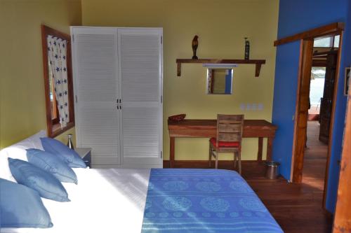 a bedroom with a bed and a desk at Kaireva Beach House in Rarotonga