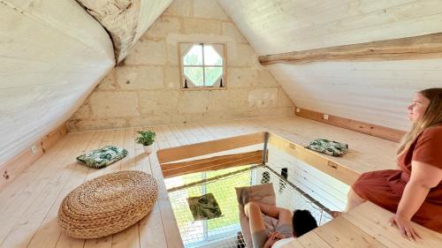 a woman is sitting in the inside of a tiny house at Gîte familial Détente entre Loir et coteau, spa-sauna, acc pmr in Les Roches-lʼÉvêque