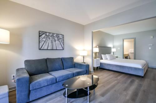 un salon avec un canapé et un lit dans l'établissement The King Studio Sauna Haven, à Shanty Bay