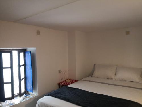 テトゥアンにあるRiad la madriguera de Tetuanのベッドと窓のある小さな寝室
