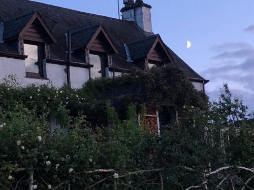 an old white house with a black roof at Ardmore House B&B in Lochinver