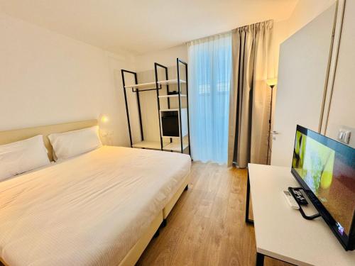 a bedroom with a bed and a desk with a computer at Hotel Pex Verona in Verona