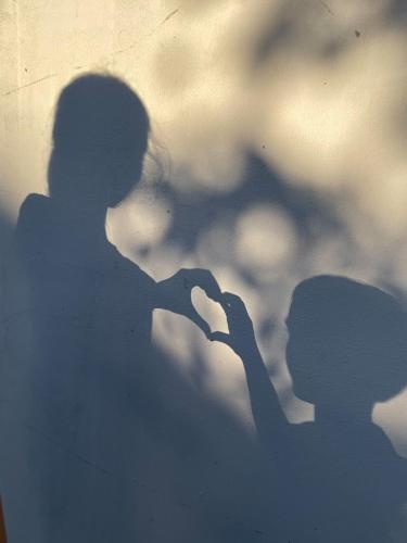 a shadow of a woman making a heart gesture at Éden Garten Vendégház in Magyarpolány