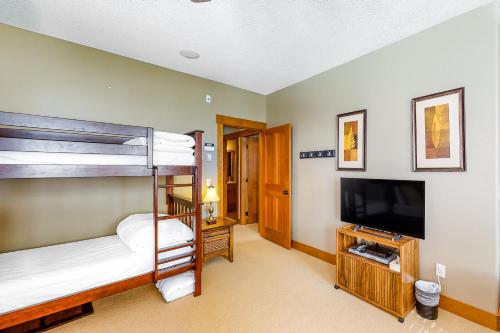 a bedroom with bunk beds and a flat screen tv at Snowbanks 6 in Big White