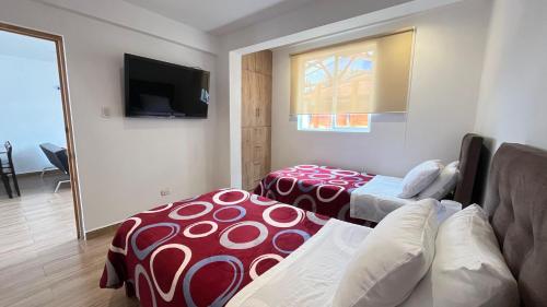 a room with two beds and a couch and a television at C4s4 RANCH OXAPAMPA in Oxapampa