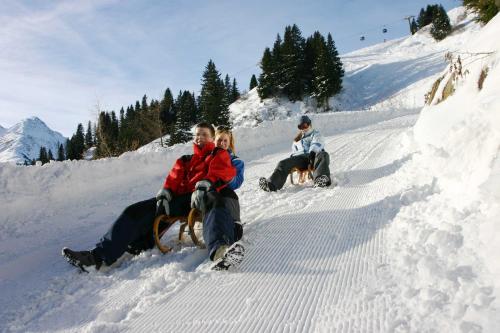 a group of people sitting in the snow at Haus Schimpfößl in Flirsch