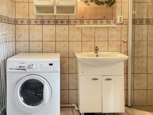 a small bathroom with a washing machine and a sink at 4 star holiday home in TYRINGE in Tyringe