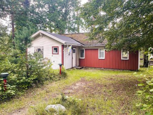 a small red and white house with a yard at 4 star holiday home in TYRINGE in Tyringe