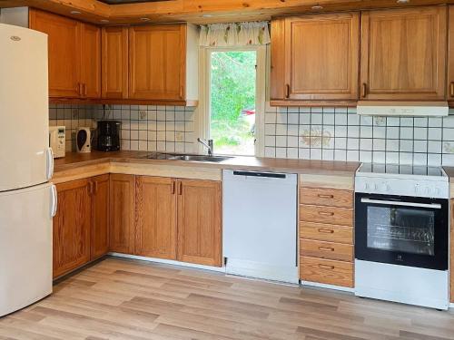 a kitchen with wooden cabinets and white appliances at 4 star holiday home in TYRINGE in Tyringe