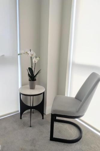 a white chair sitting next to a table with a plant at GGP Boutique Townhome in Vaughan