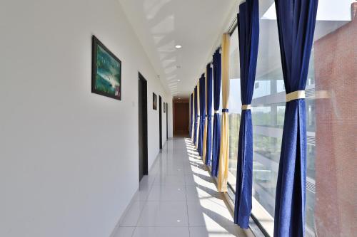 a hallway with blue curtains in a building at Hotel Infinity in Vadodara