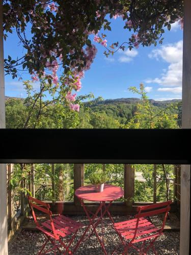 a table and two chairs on a porch with a view at Ardmore House B&B in Lochinver