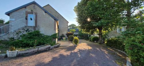 a house with a tree and a driveway at Chambre Étape Carosselle in Saint-Vaury