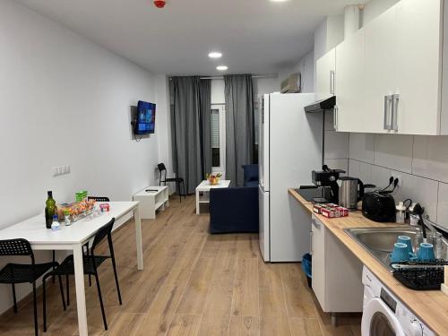a kitchen with white cabinets and a table with chairs at Golondrinas de Alicante in Alicante