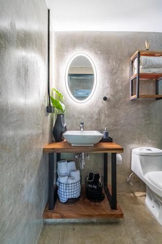 a bathroom with a sink and a window at Z102 Studios, 4 Industrial Beach Condos w Pool! in Playa Flamingo