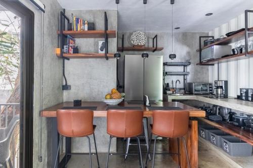a kitchen with a wooden table and chairs at Z102 Studios, 4 Industrial Beach Condos w Pool! in Playa Flamingo