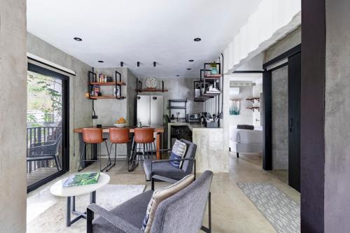 a kitchen and living room with chairs and a table at Z102 Studios, 4 Industrial Beach Condos w Pool! in Playa Flamingo