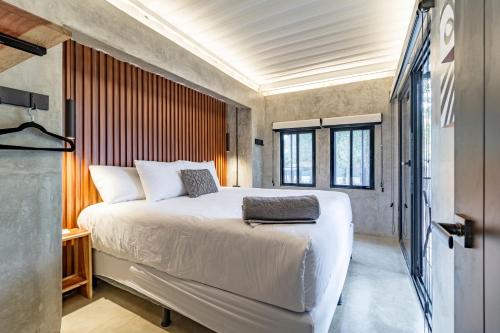 a bedroom with a large bed and a window at Z102 Studios, 4 Industrial Beach Condos w Pool! in Playa Flamingo