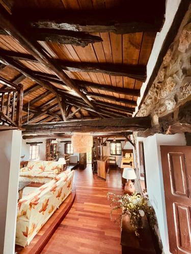 a large living room with wooden ceilings and wooden floors at HdeC Hosteria de Castañeda Alojamiento Turistico in Puente Viesgo