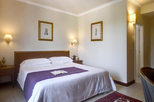 a bedroom with a large bed with a purple blanket at Villa Cattani Stuart XVII secolo in Pesaro
